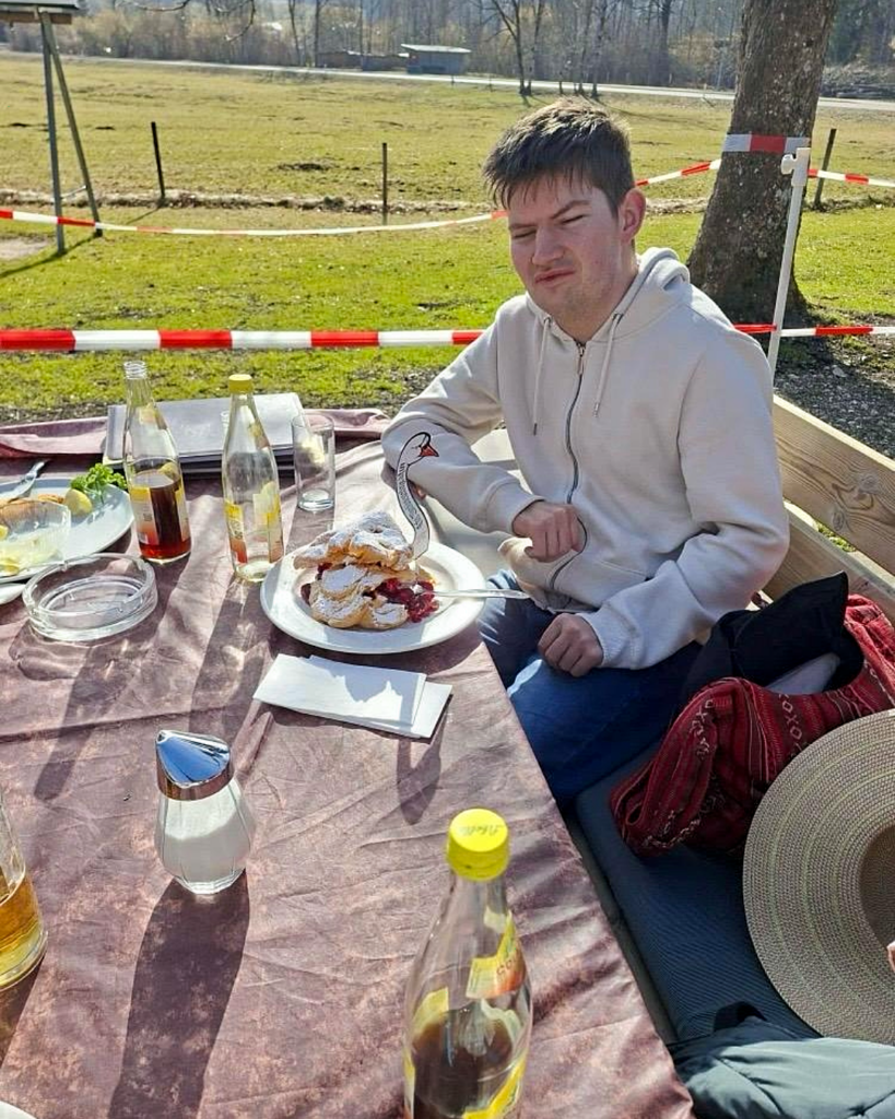 Ein Mitglied der WG mit Herz vor einem Tisch voller Speisen