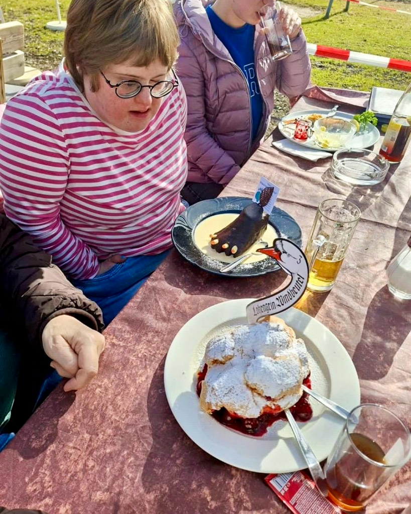 Ein Mitglied der WG mit Herz an einem Tisch voller Speisen